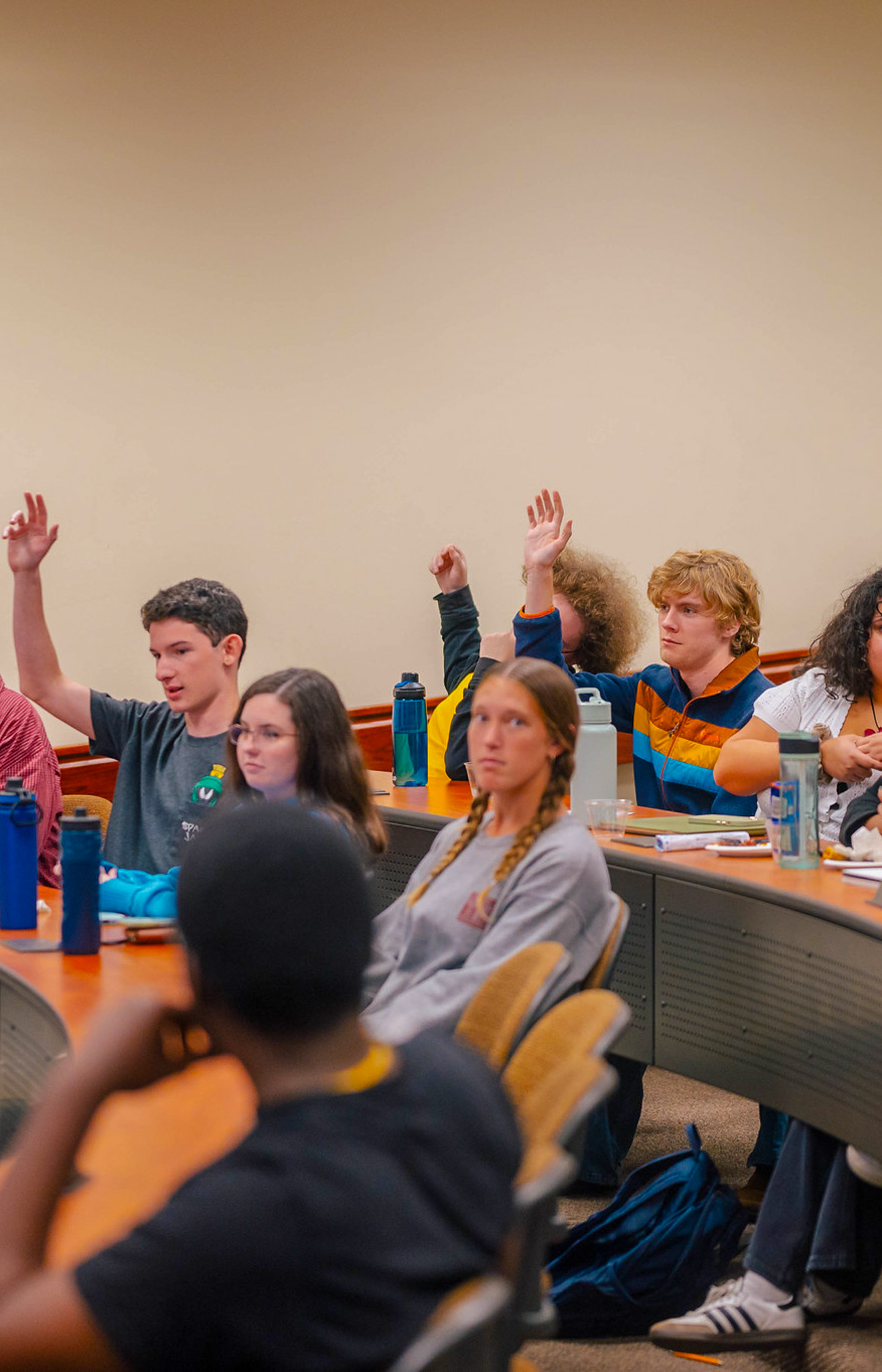 Students raising hands during classroom discussion